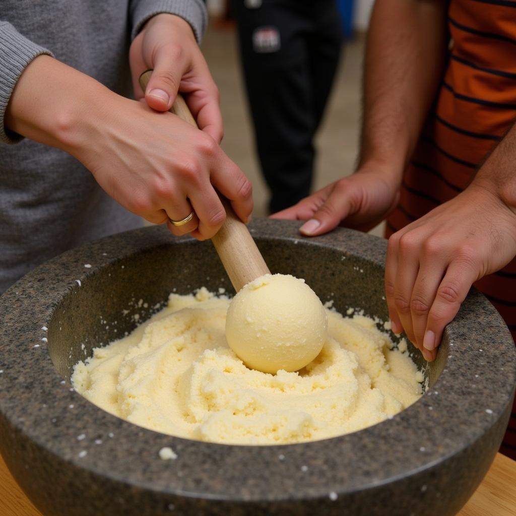 Two people using a mortar and pestle to pound fufu, demonstrating the traditional method of preparation.