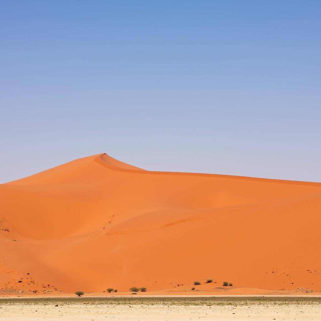 Majestic Sossusvlei Sand Dunes: Towering orange sand dunes against a clear blue sky in the Namib Desert, a breathtaking display of nature's artistry.